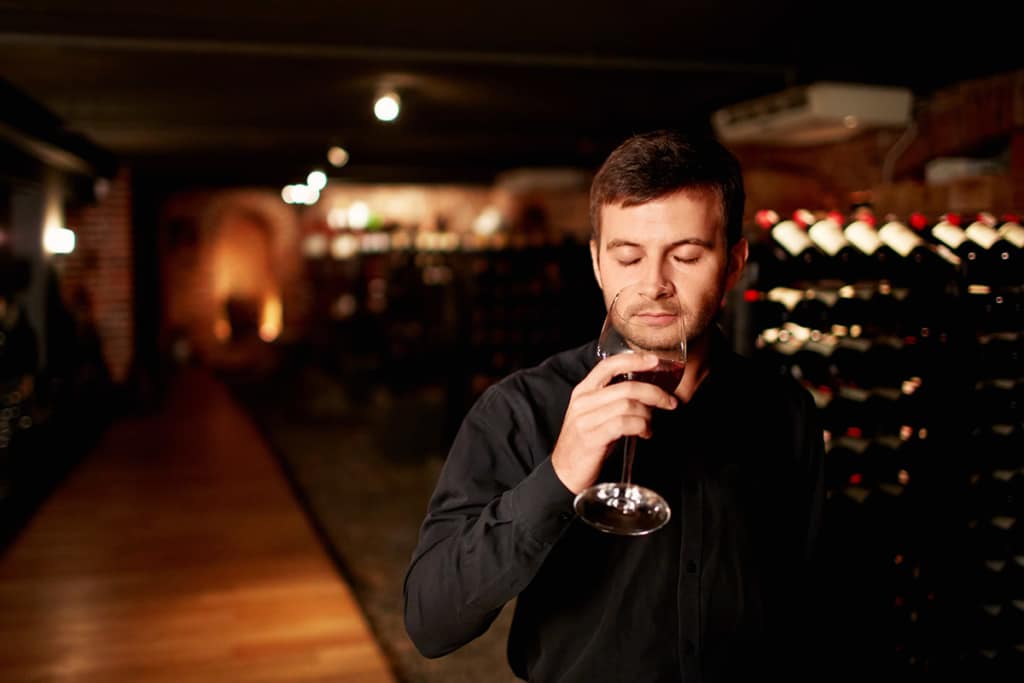 oenologue respire le vin dans une cave à chinon